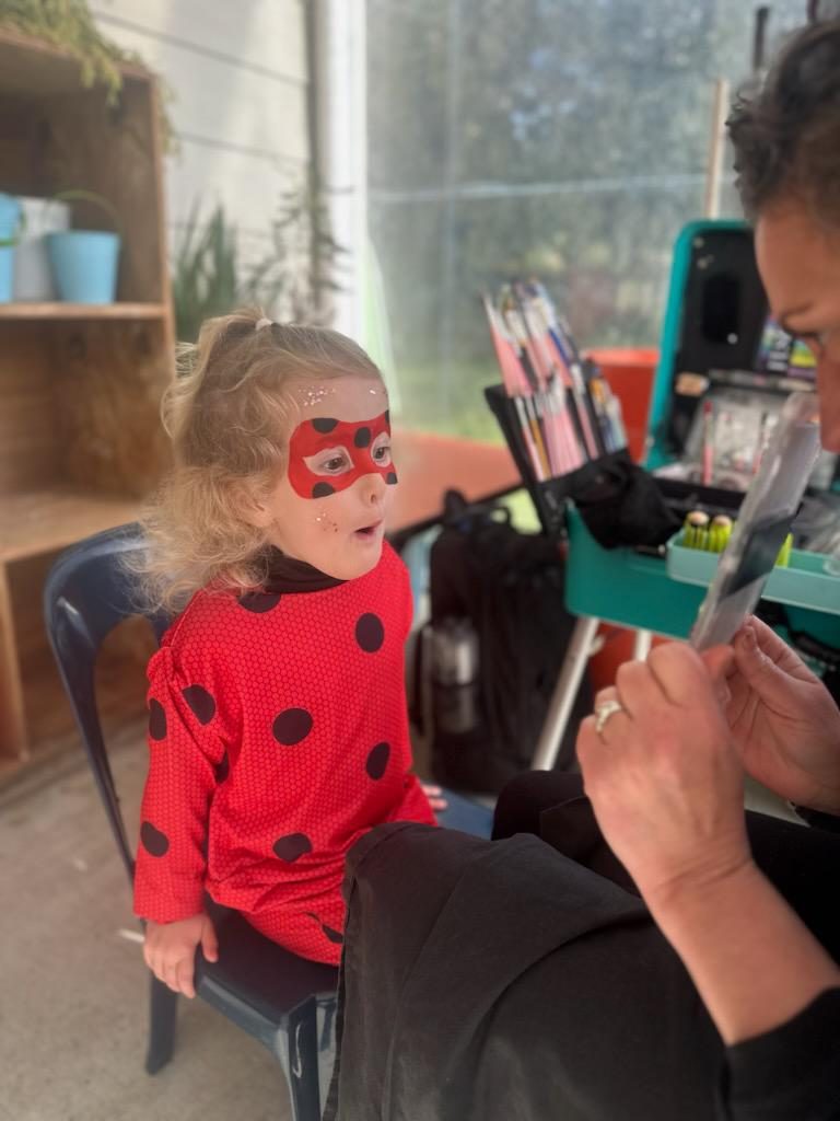 Child with full-face superhero design — Little Smiles face painting Auckland